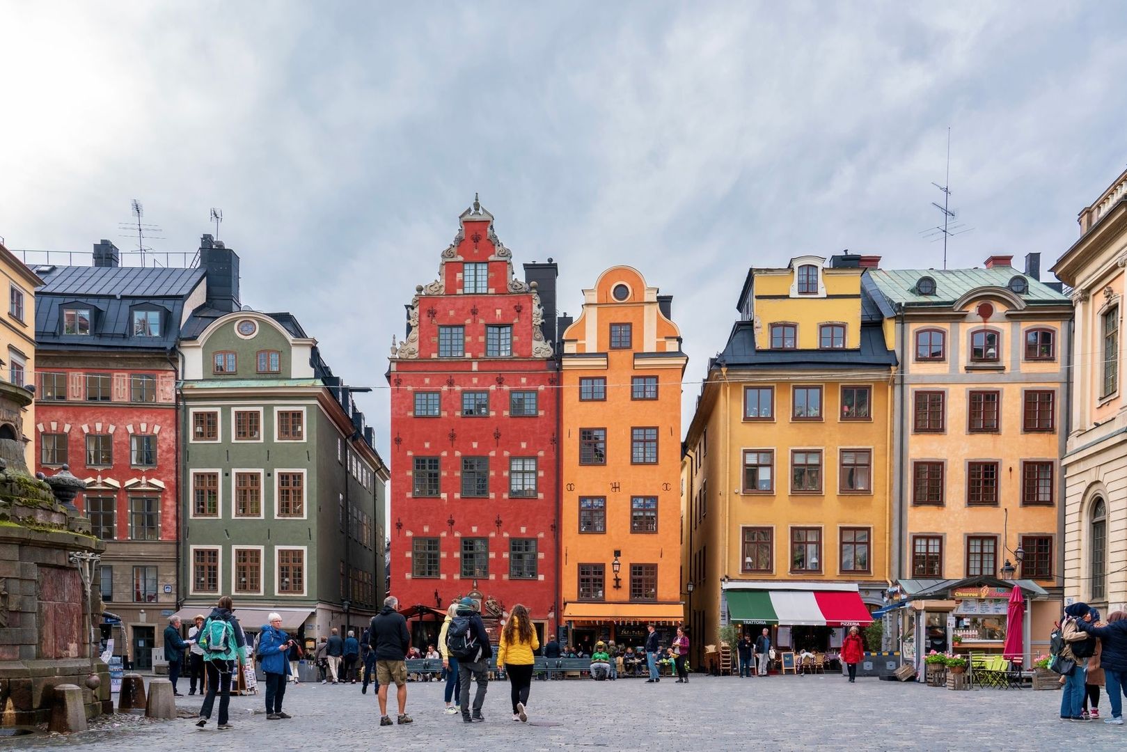 Färgstarka historiska hus och människor på ett livligt svenskt torg